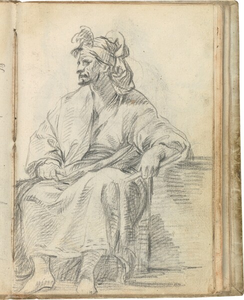 Figura masculina sentada, con un bastón en su mano izquierda y tocada con turbante